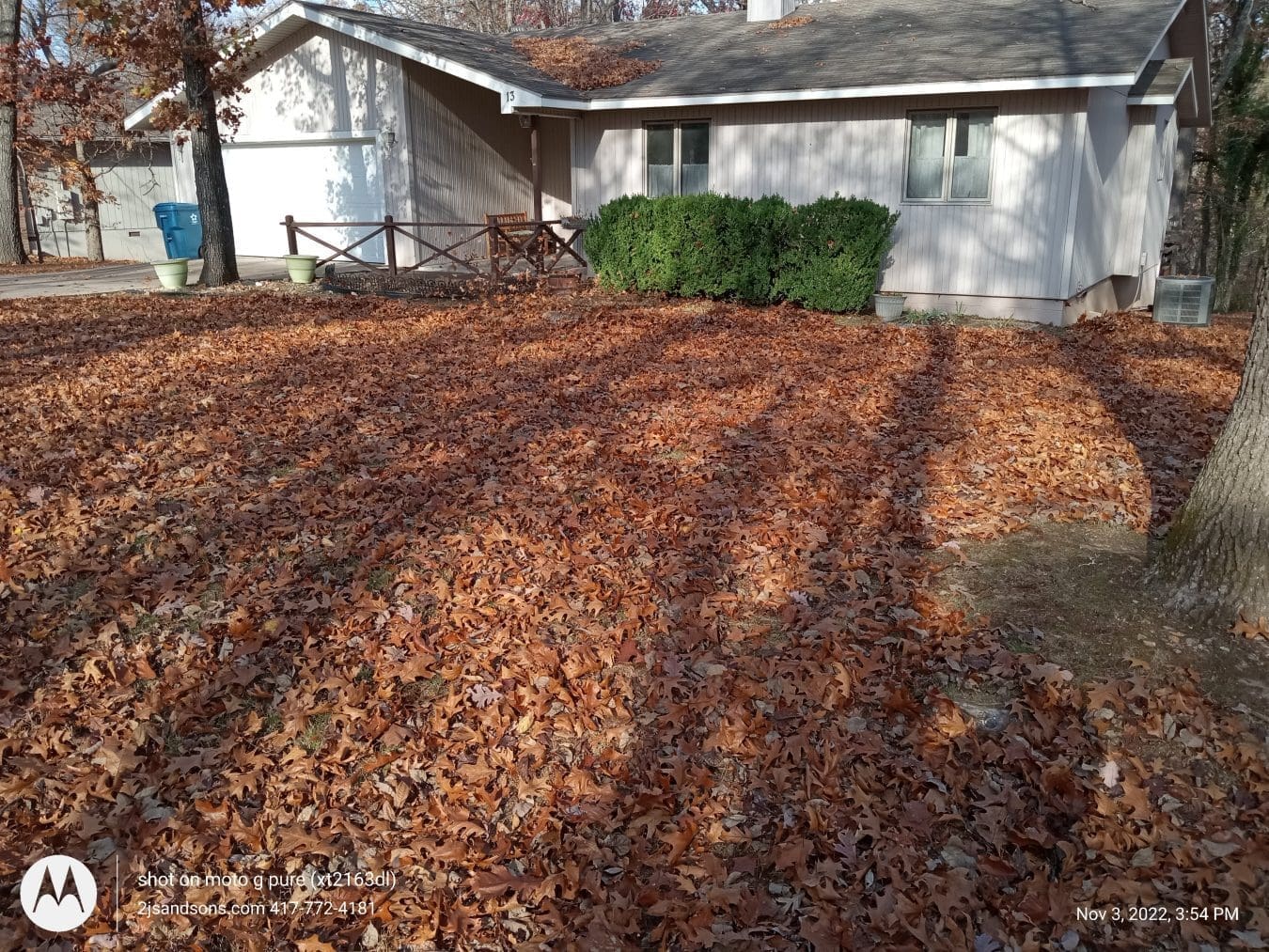 Fall lot cleanup with leaves being removed from a gravel yard.